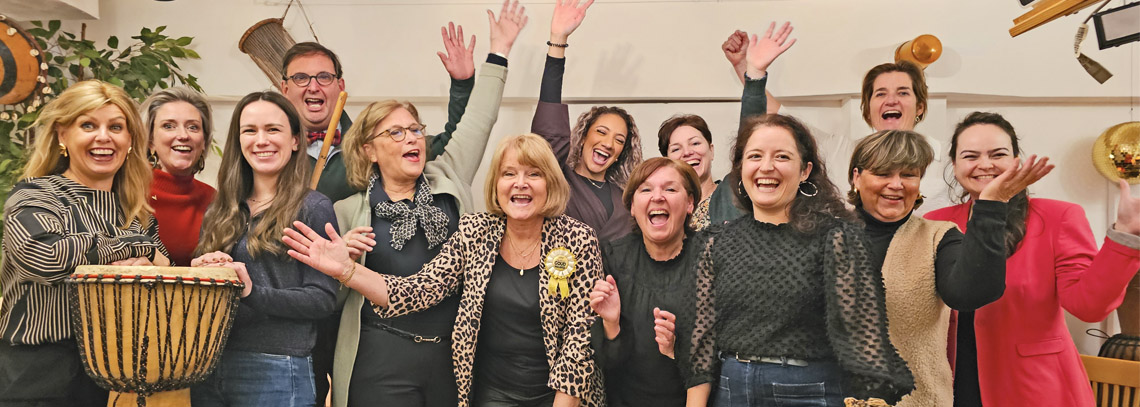 Blije deelnemers met djembe trommels na een geslaagde workshop teambuilding in Tilburg